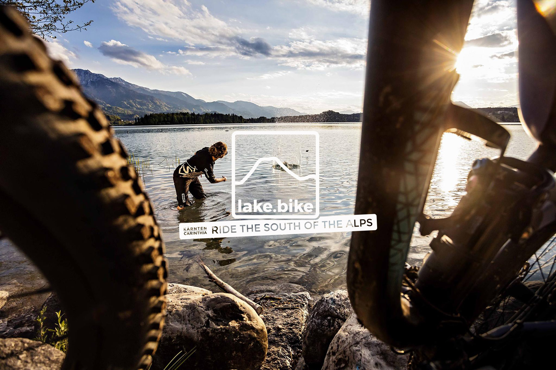 lake.bike Mountainbiker throwing a stone into Faaker See.